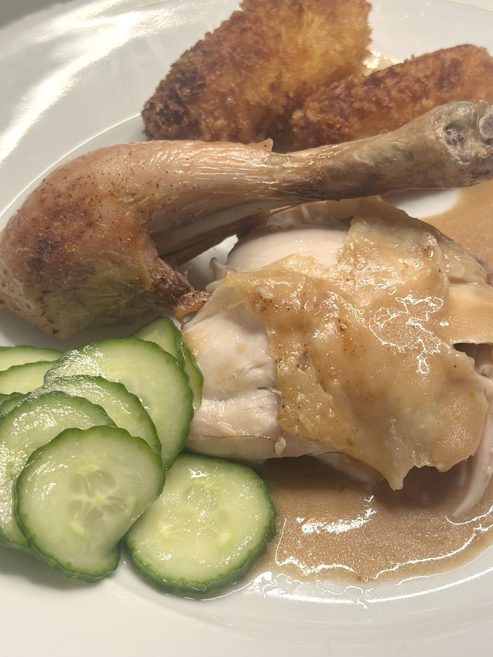Kartoffelkroketter serveret med helstegt kylling, sovs og agurkesalat