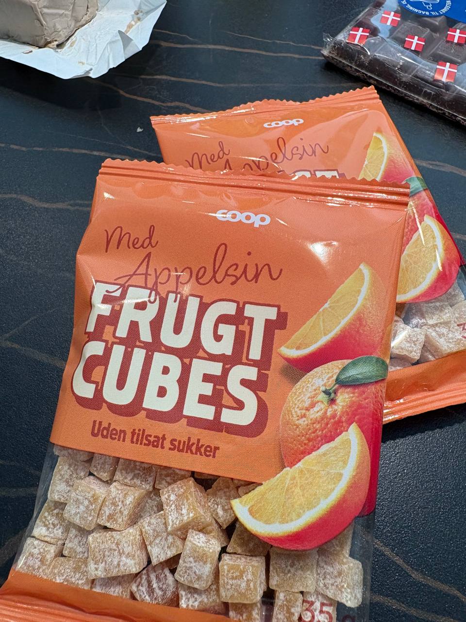 Poser med tørrede appelsinstykker uden tilsat sukker og en plade mørk chokolade